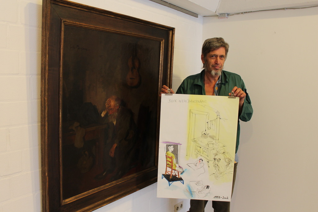 Das Bild zeigt den Künstler Martin Lersch vor einem Bild von Gerhard Janssen: Blick in ein Bauernhaus, o.J. Öl auf Leinwand,65 x 50 cm